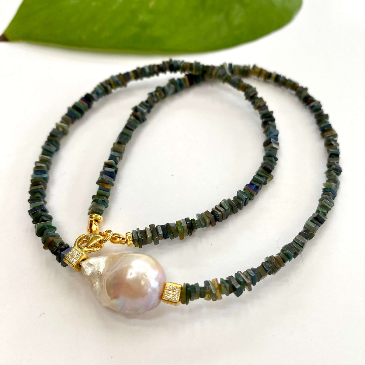 Black opal pearl necklace displayed on white cloth table