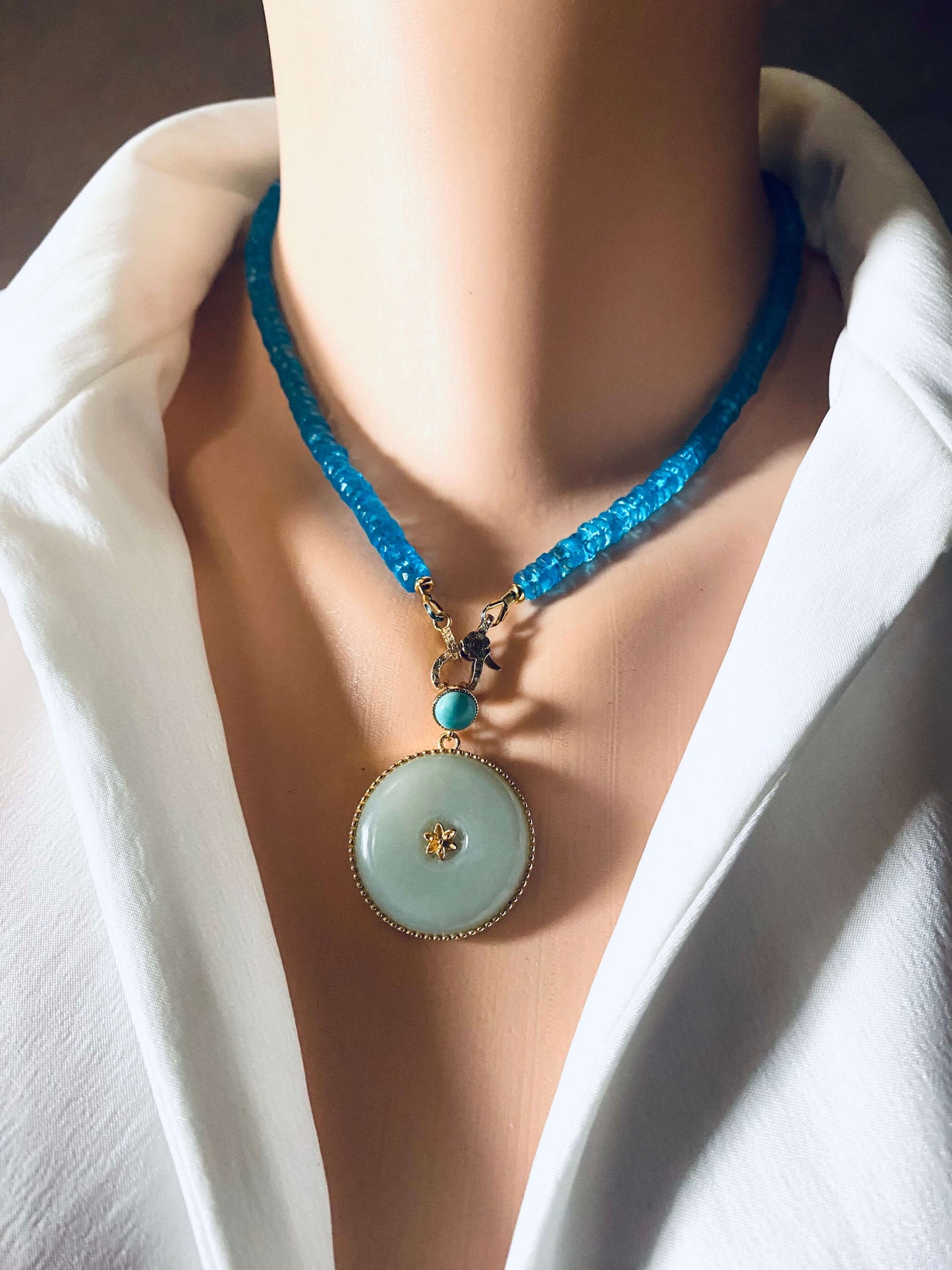 Blue topaz beaded necklace with gold vermeil pavé clasp worn by a mannequin, showcasing vibrant color and elegance.