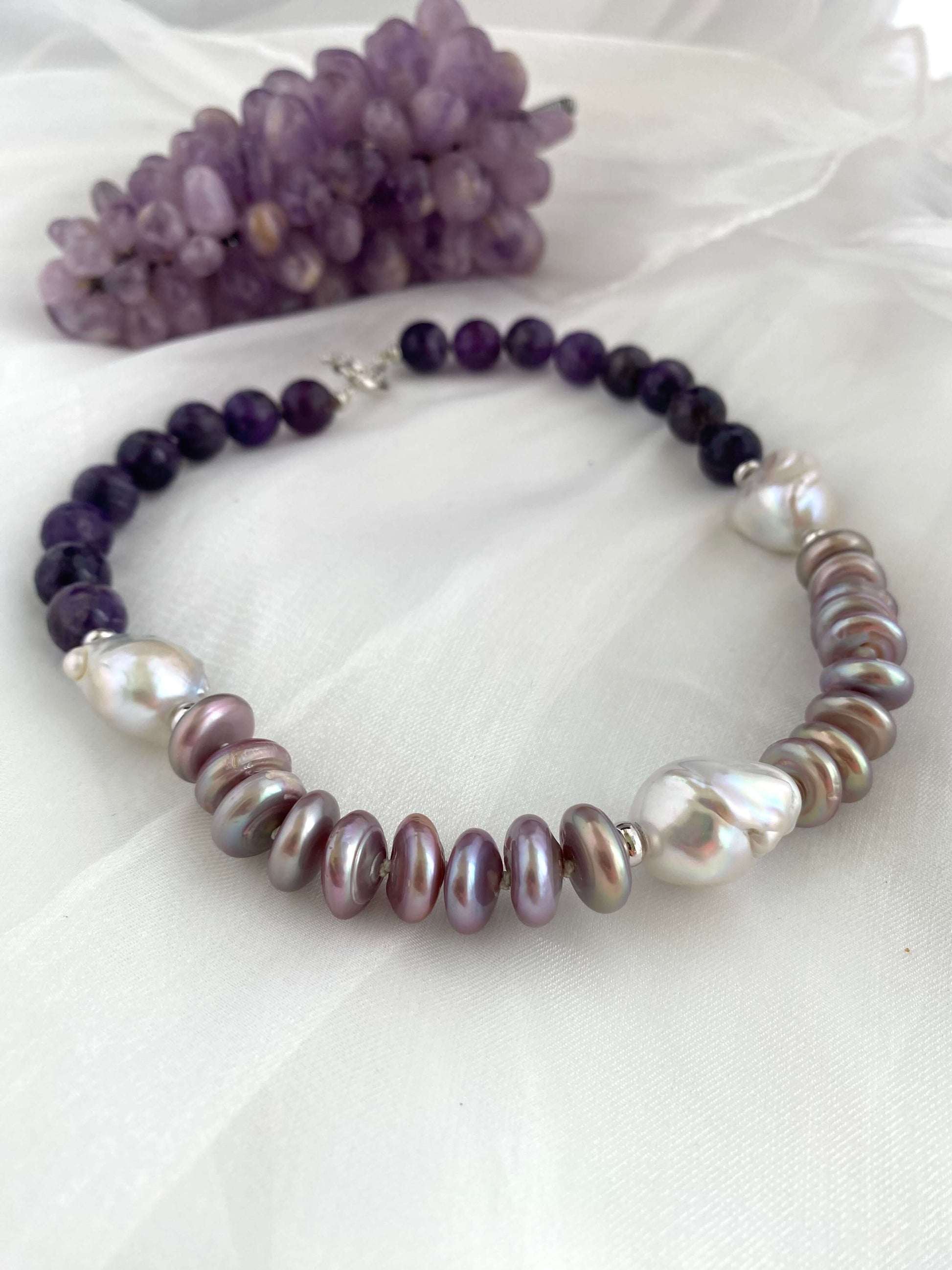 Amethyst pearl necklace featuring baroque and coin pearls, showcasing elegant design and rich colors.