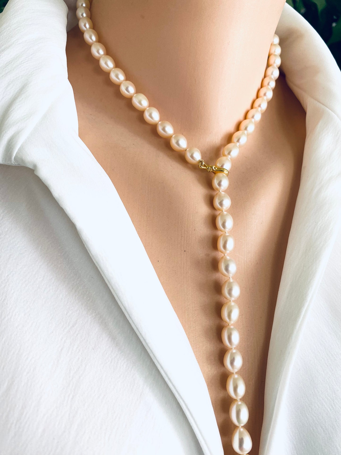 Pearl necklace worn by a person in a white outfit