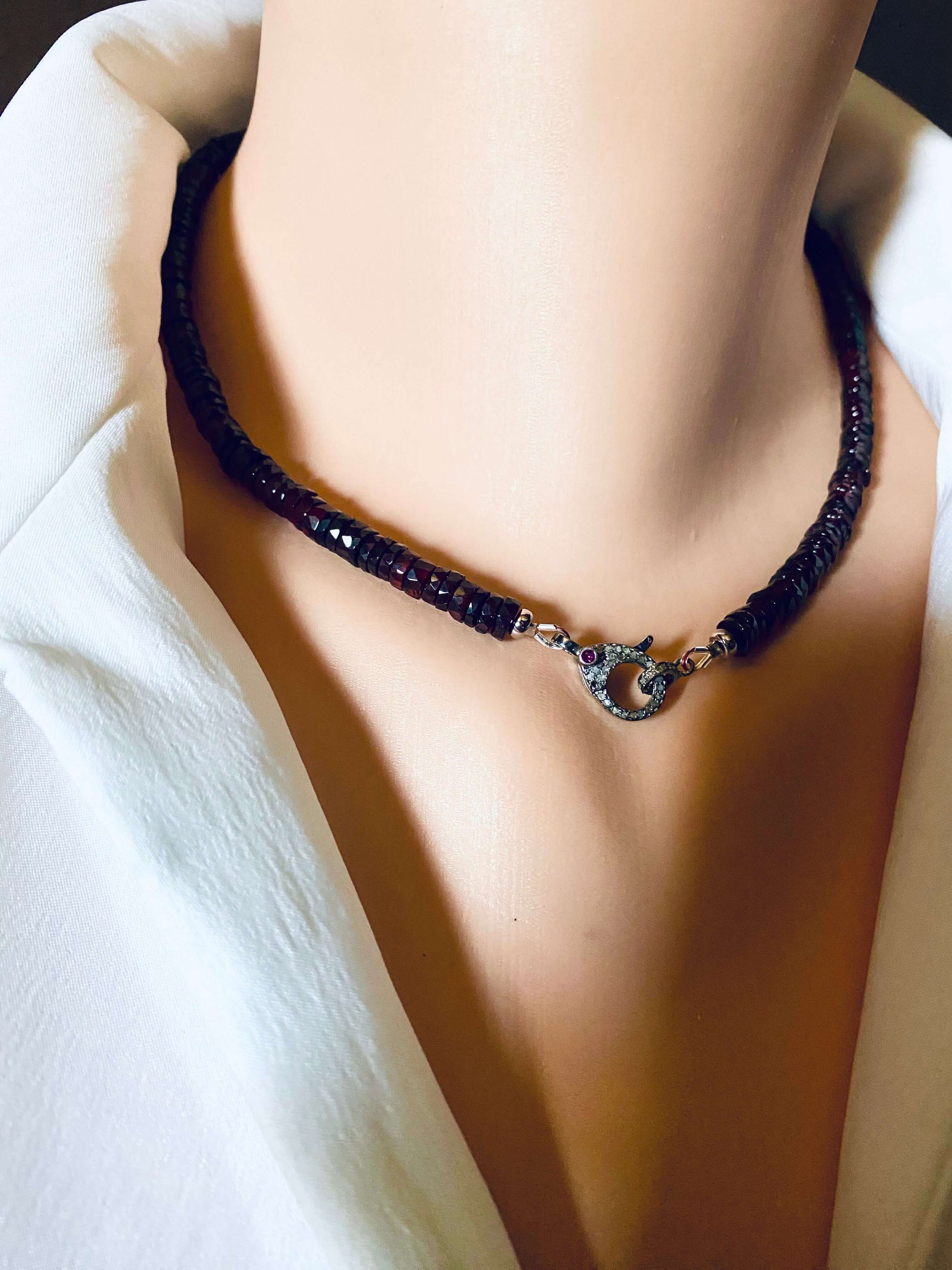 Garnet beaded necklace featuring a diamond and ruby pavé clasp, showcasing rich wine-red tones.