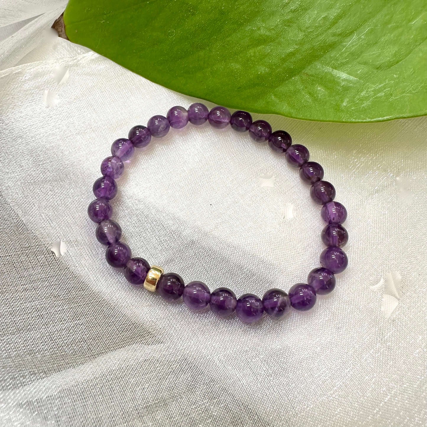 Amethyst Bracelet displayed on white cloth – gemstone bead close-up