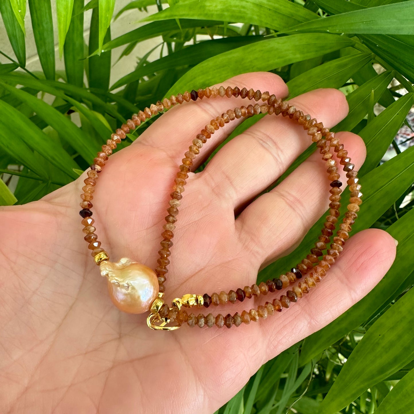 Hessonite garnet baroque pearl necklace featuring warm colors and unique golden pink pearl design.