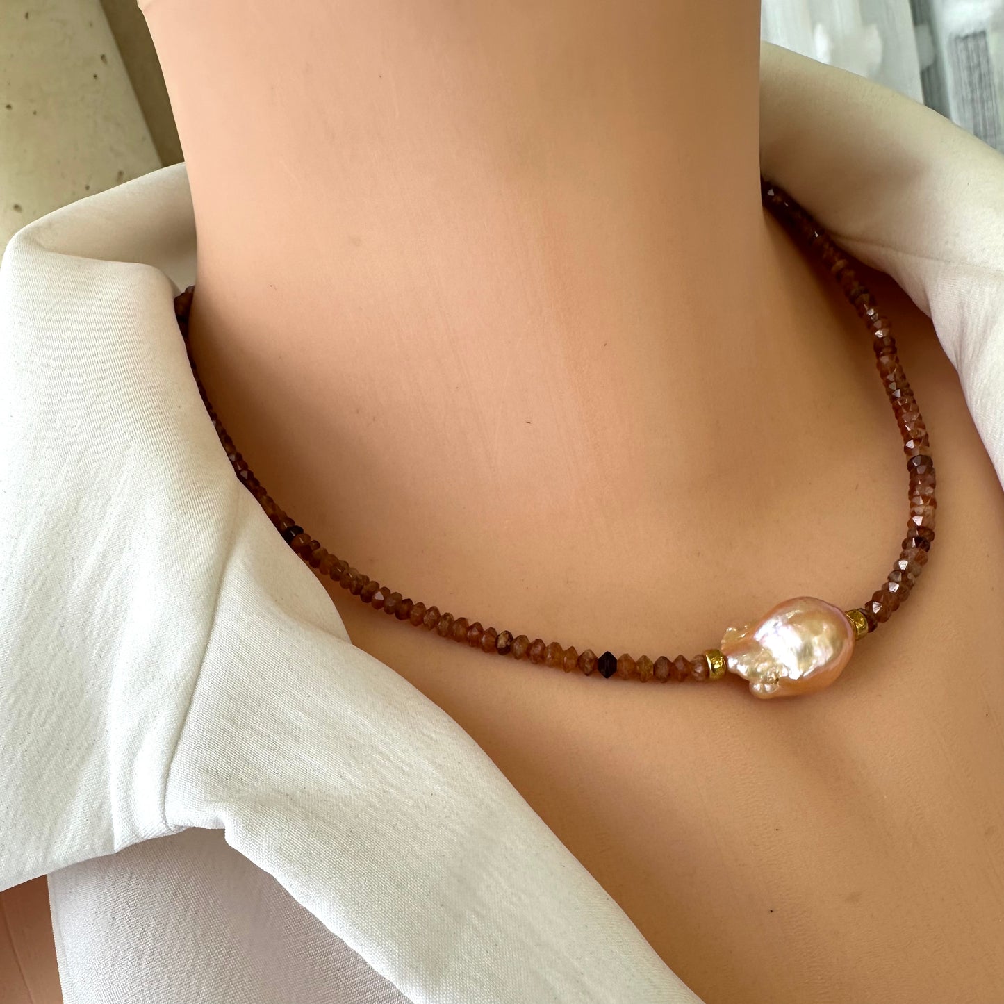 Hessonite garnet baroque pearl necklace featuring golden pink baroque pearl displayed on a mannequin.
