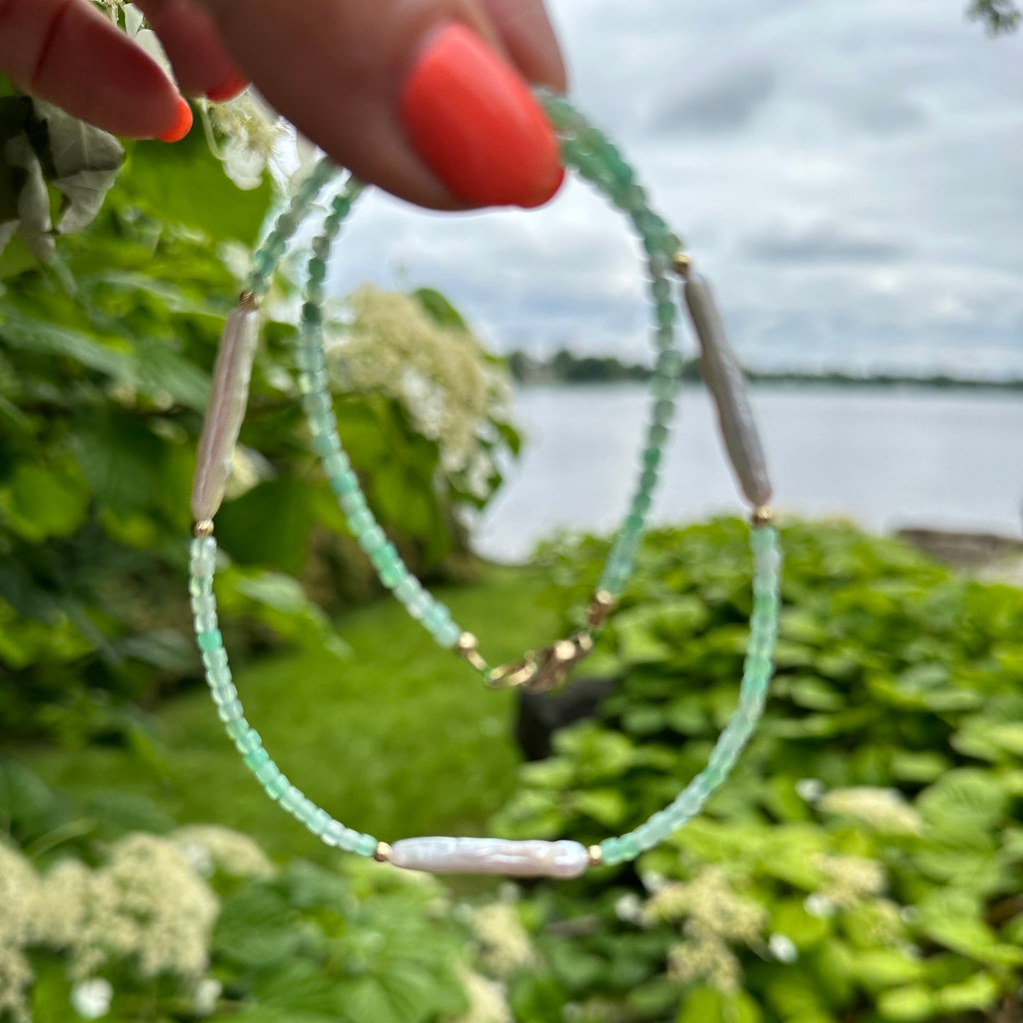 Green Chrysoprase Necklace held in hand against summer foliage – outdoor close-up