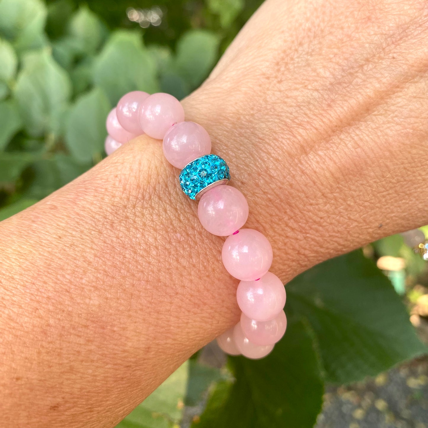 Blue sponge rose quartz pearl stretchy bracelet worn on wrist showing pink rose quartz variation