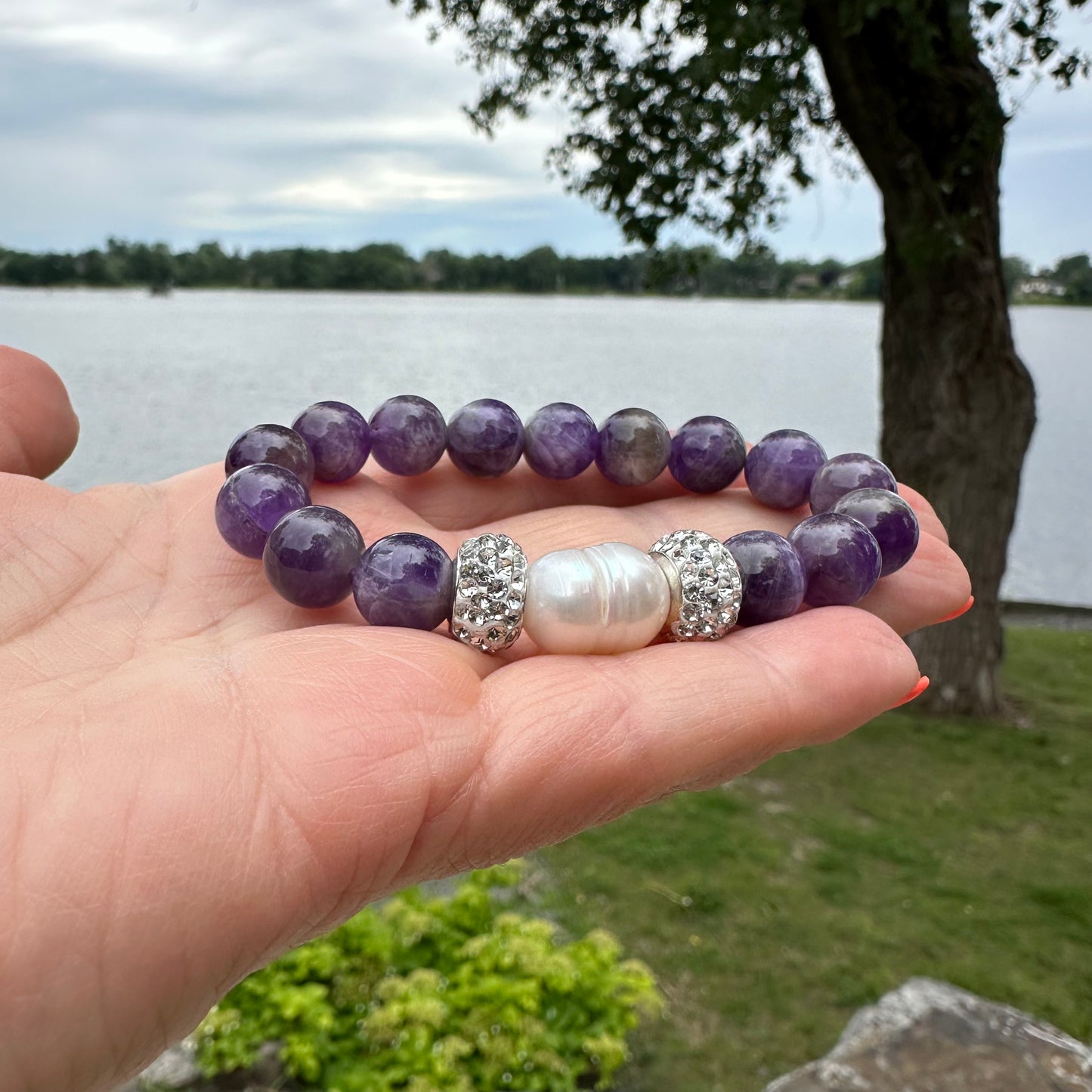 Chevron amethyst bracelet held in hand in natural outdoor light