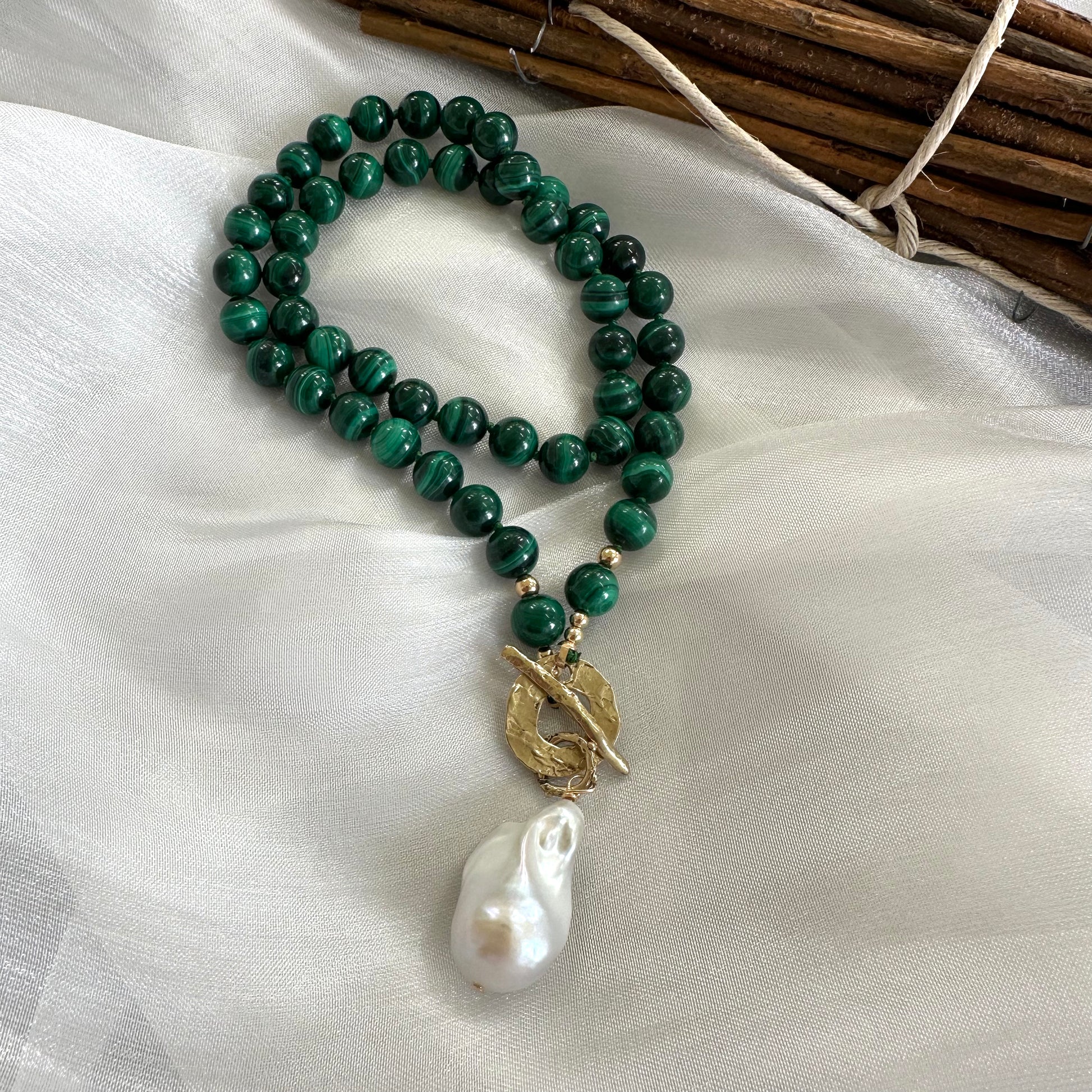 Malachite toggle necklace with baroque pearl pendant showcasing vibrant green gemstones and artisan craftsmanship.