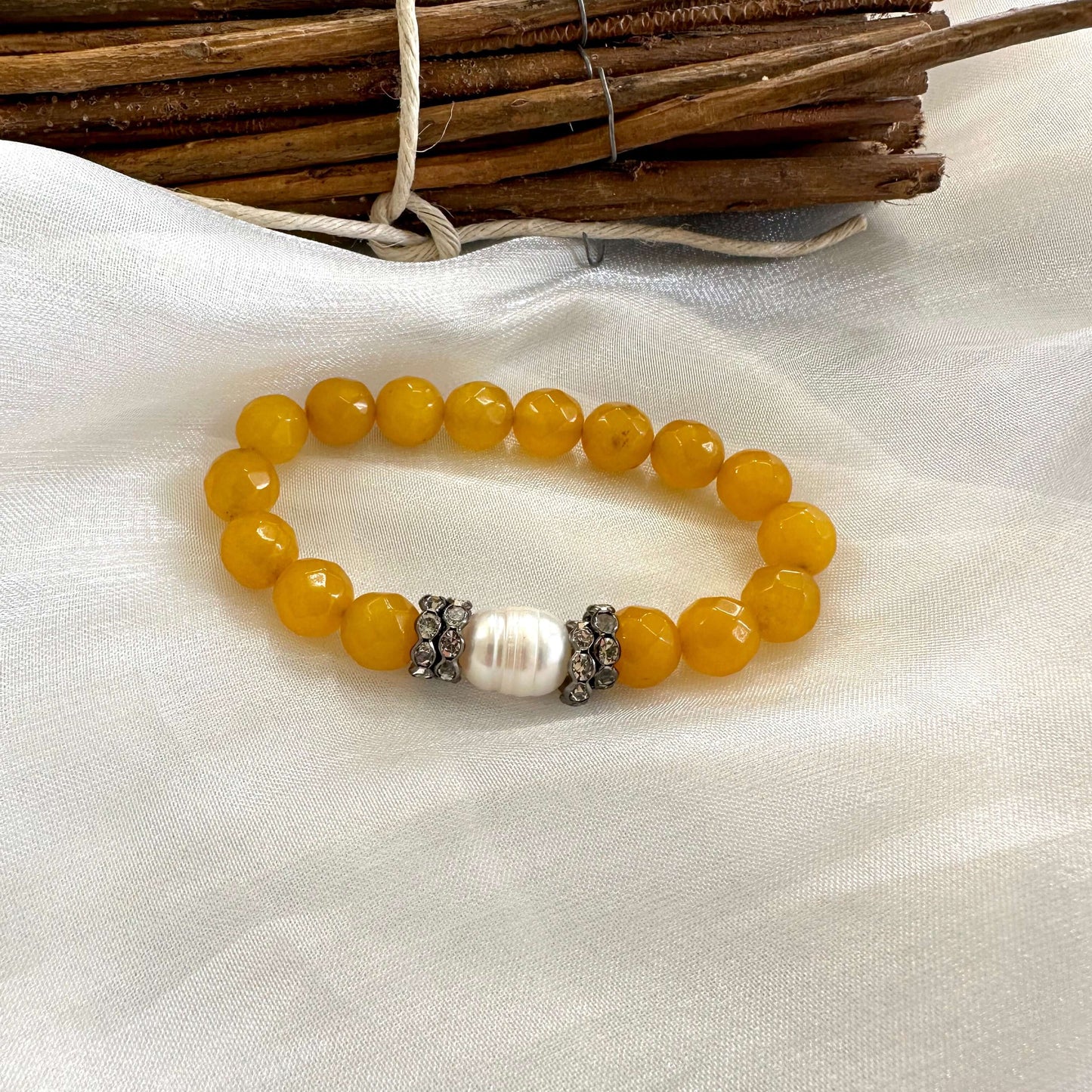 Yellow jade pearl bracelet displayed on white cloth