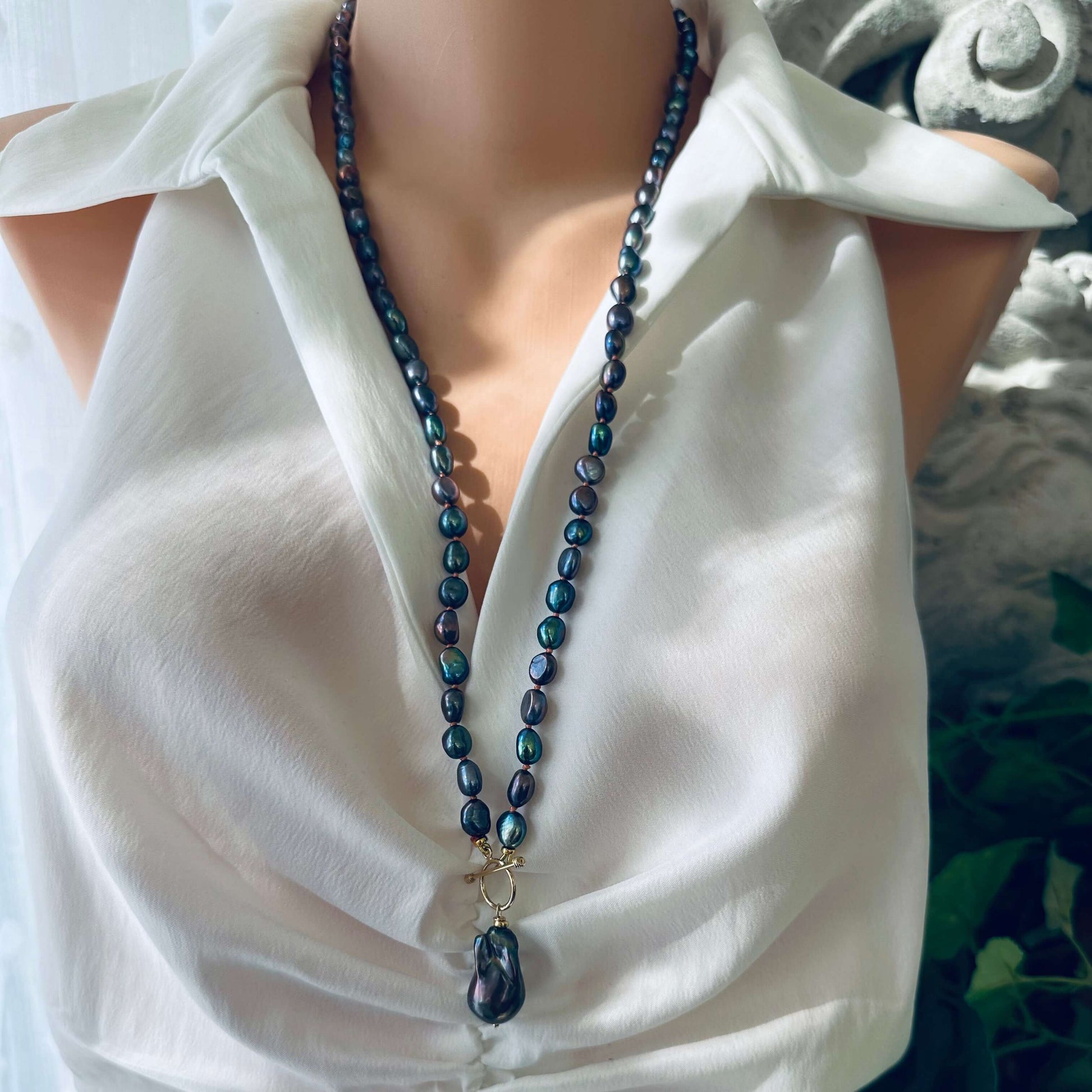 Peacock black pearl necklace with baroque pendant worn long on mannequin