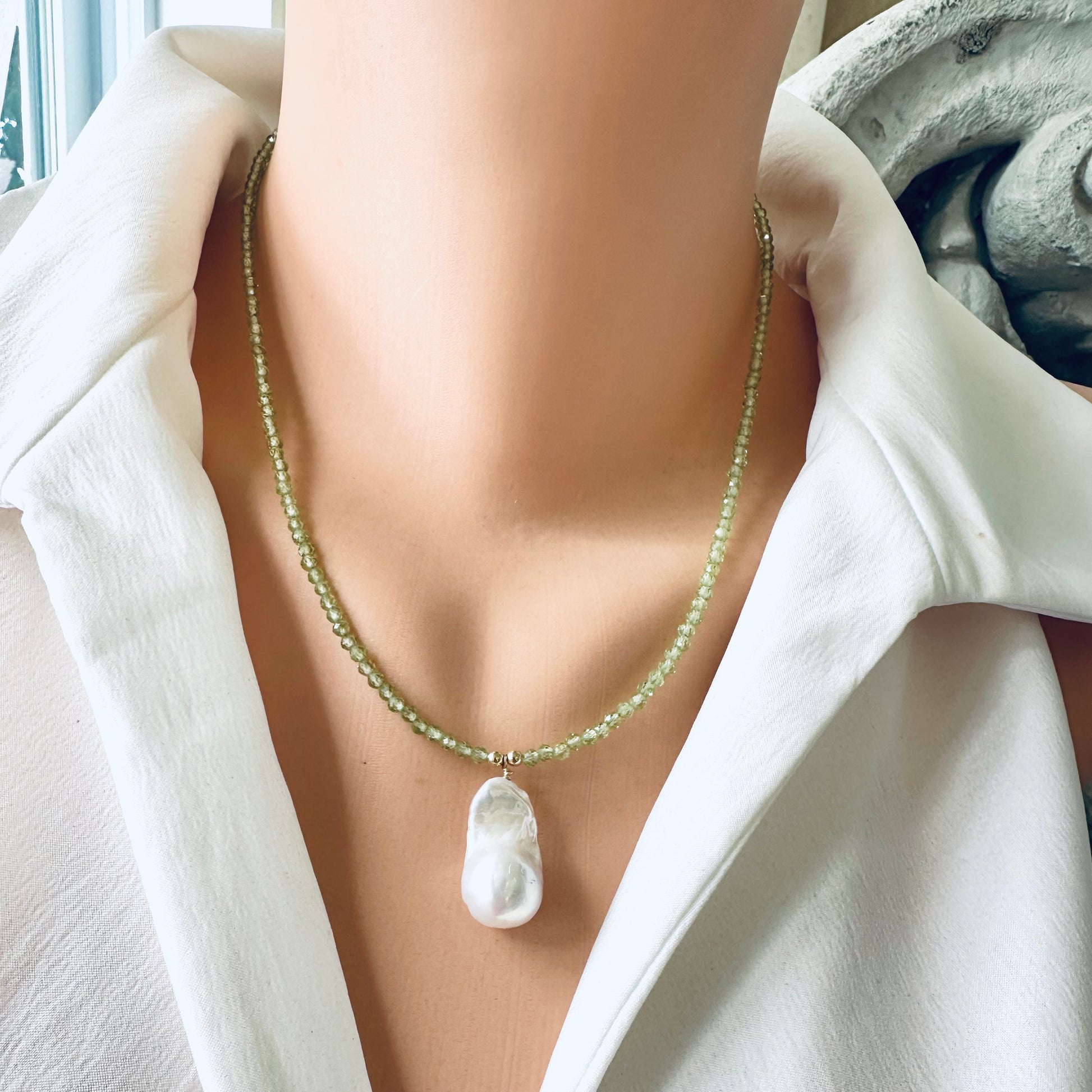 Peridot beaded necklace with baroque pearl pendant styled on mannequin, close-up