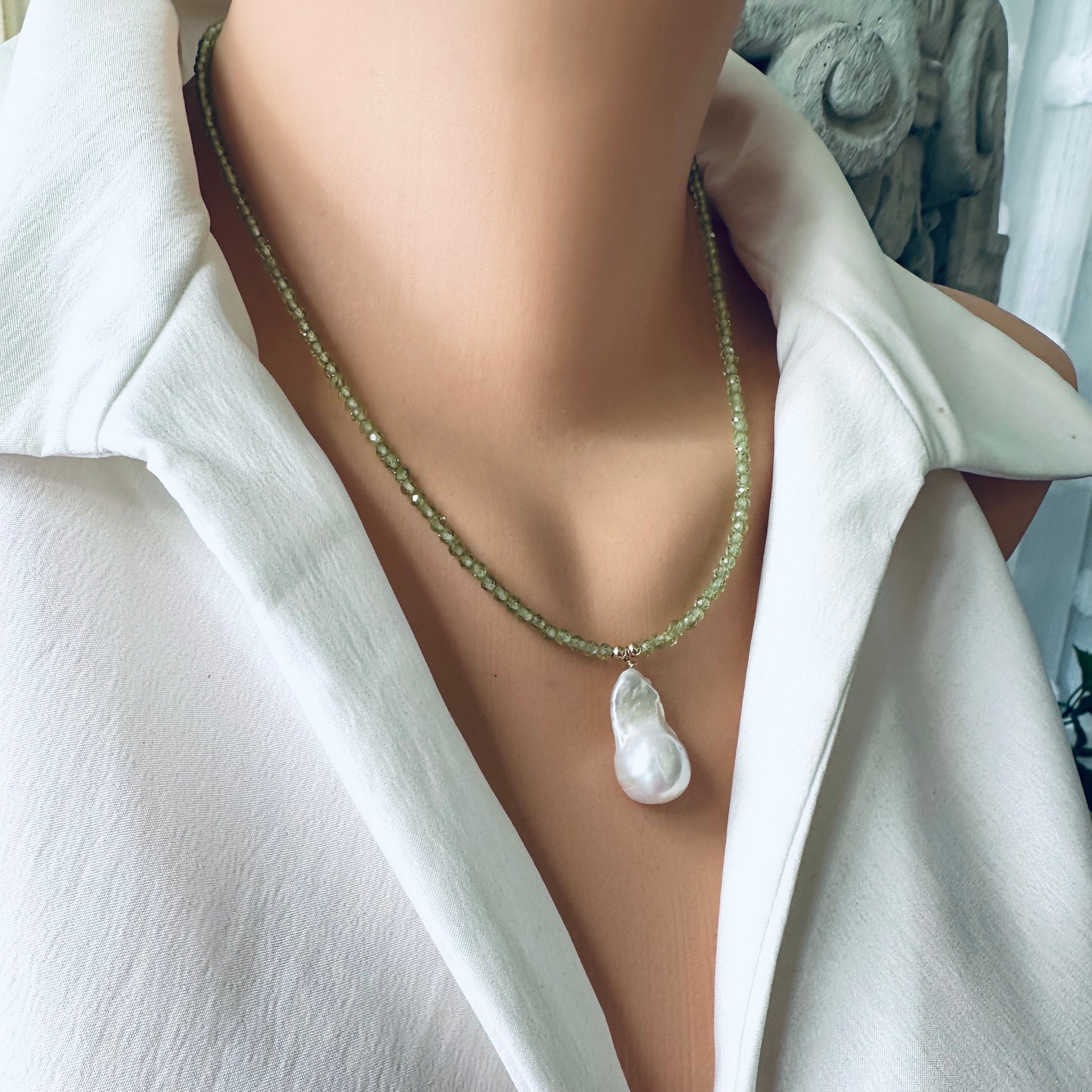 Front view of peridot beaded necklace with baroque pearl pendant on mannequin