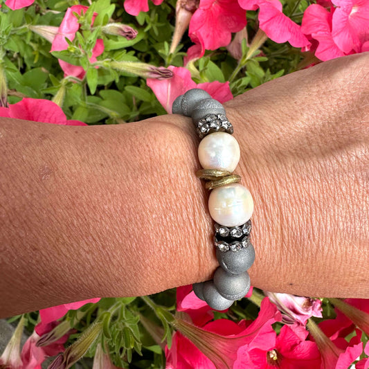 Grey druzy agate and pearl bracelet worn on female model’s wrist