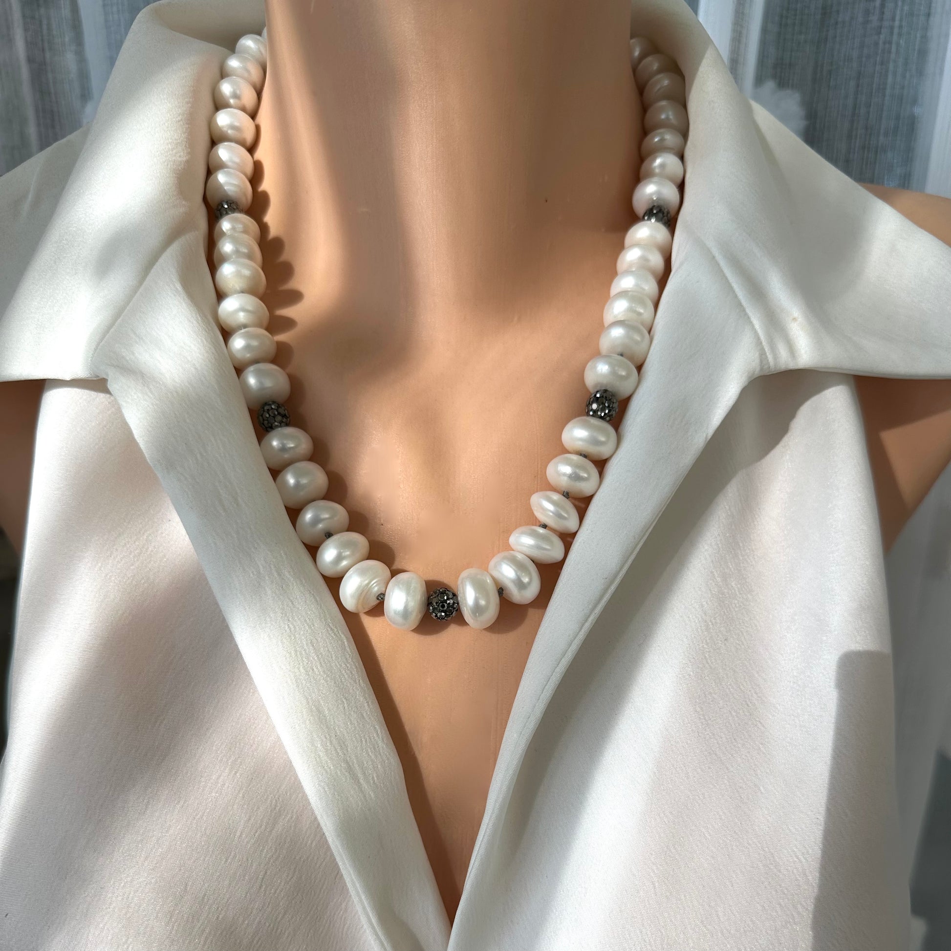 Front close-up of white button pearl necklace with rhinestone pave beads on mannequin