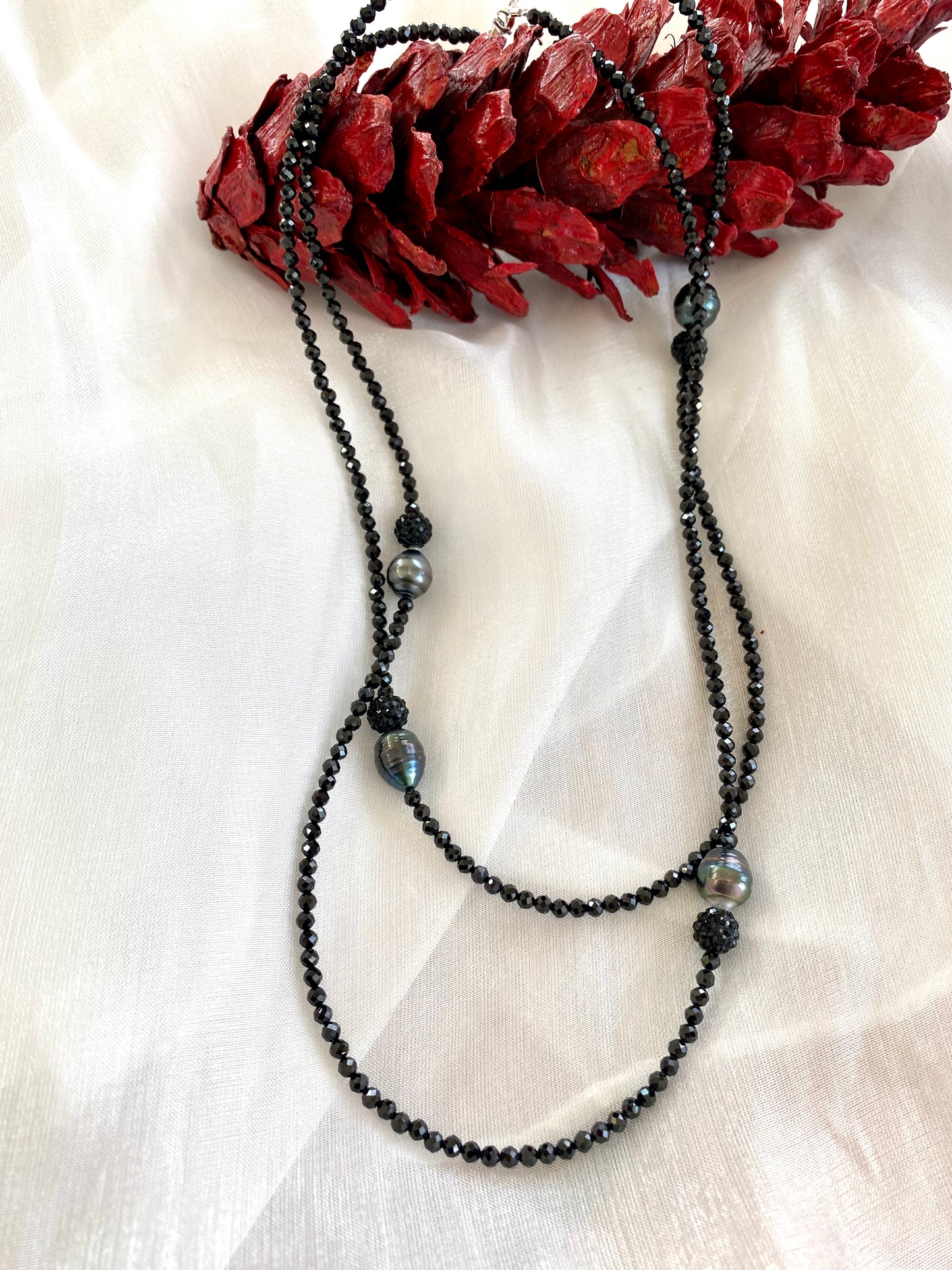 Black spinel pearl necklace on mannequin, close-up gemstone view