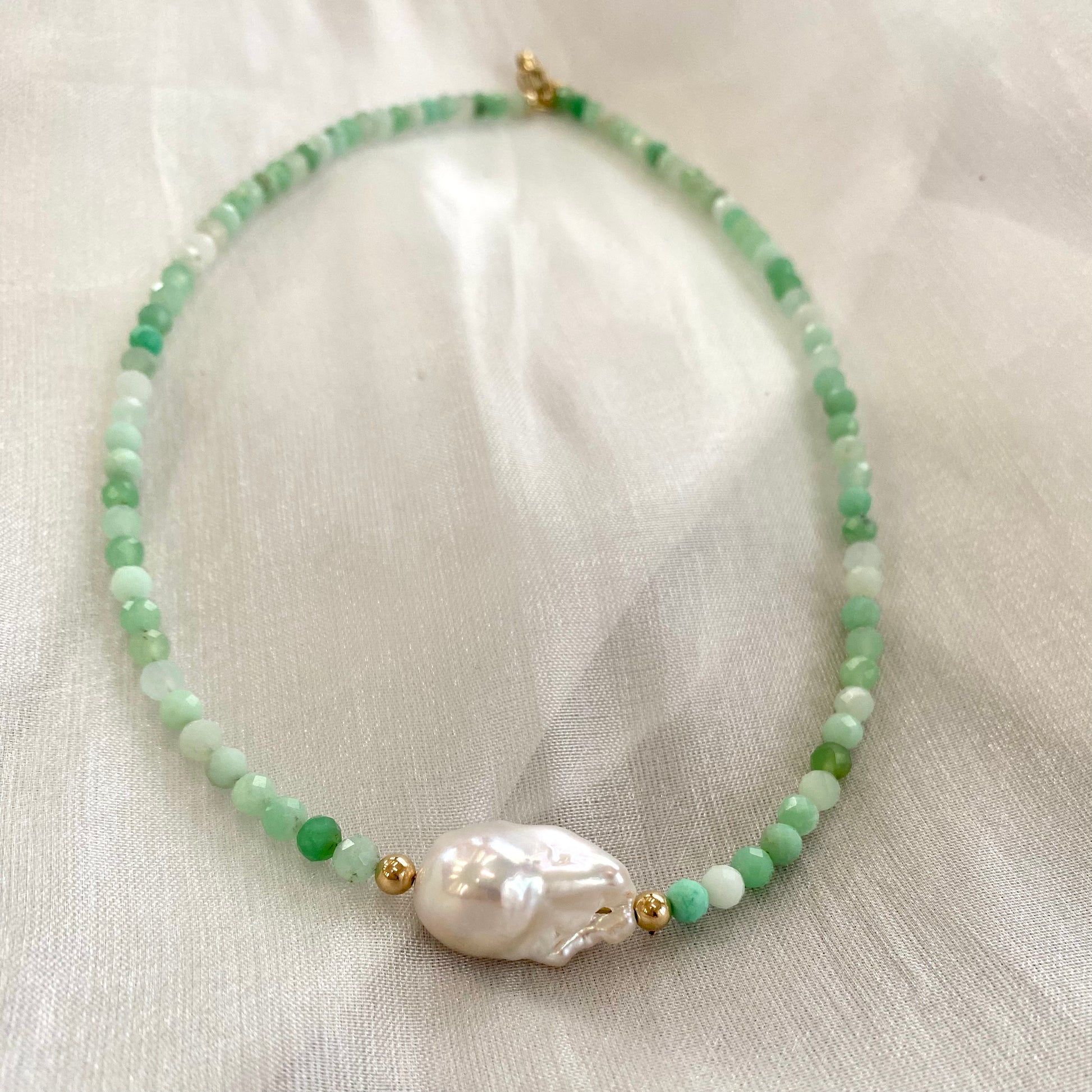 Chrysoprase pearl necklace displayed on white cloth