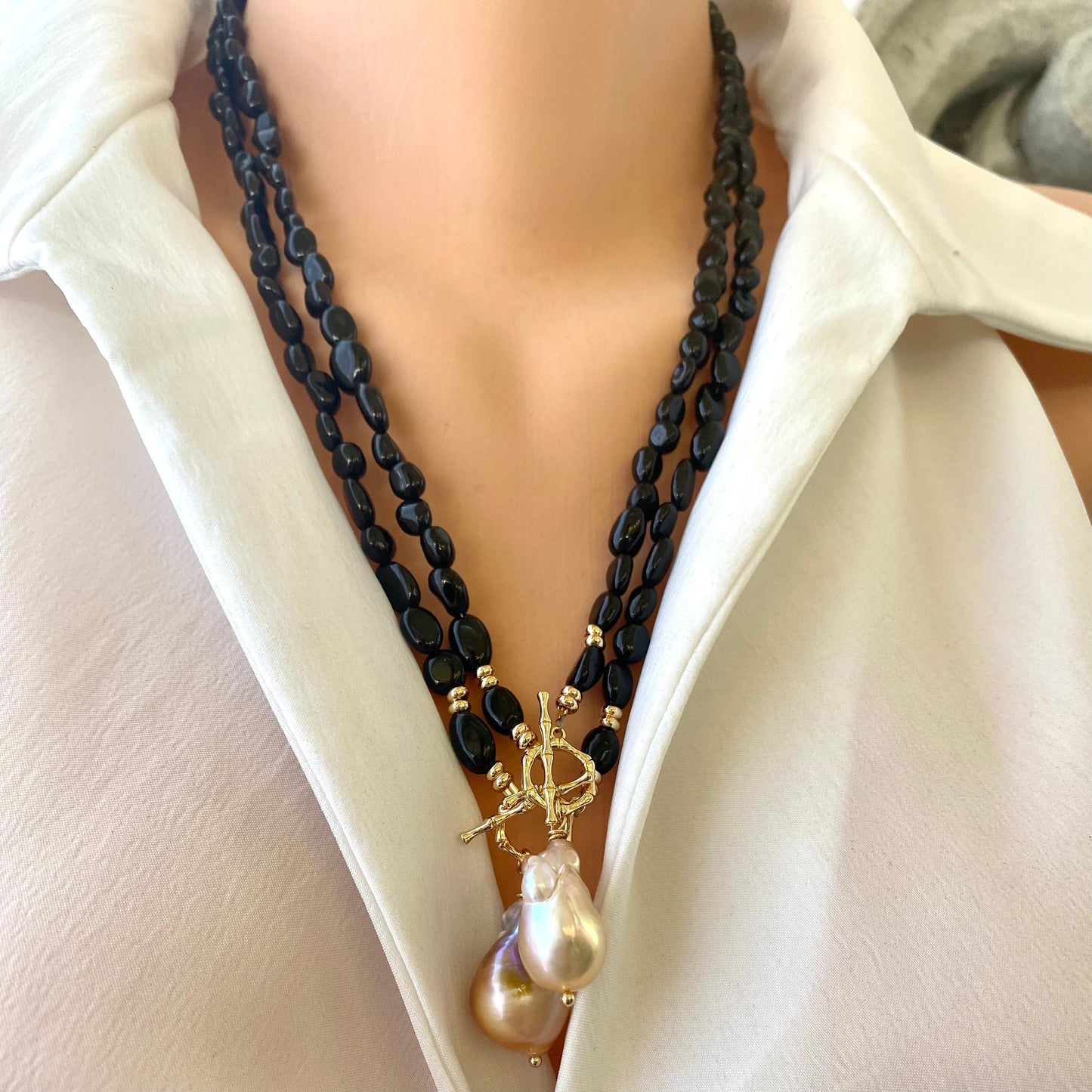 Black tourmaline pearl necklace worn on mannequin, close-up detail