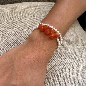 double wrap bracelet, featuring one long strand of lustrous freshwater pearls 4mm accented by stunning deep orange Carnelian Onion briolettes. Gold filled lobster clasp