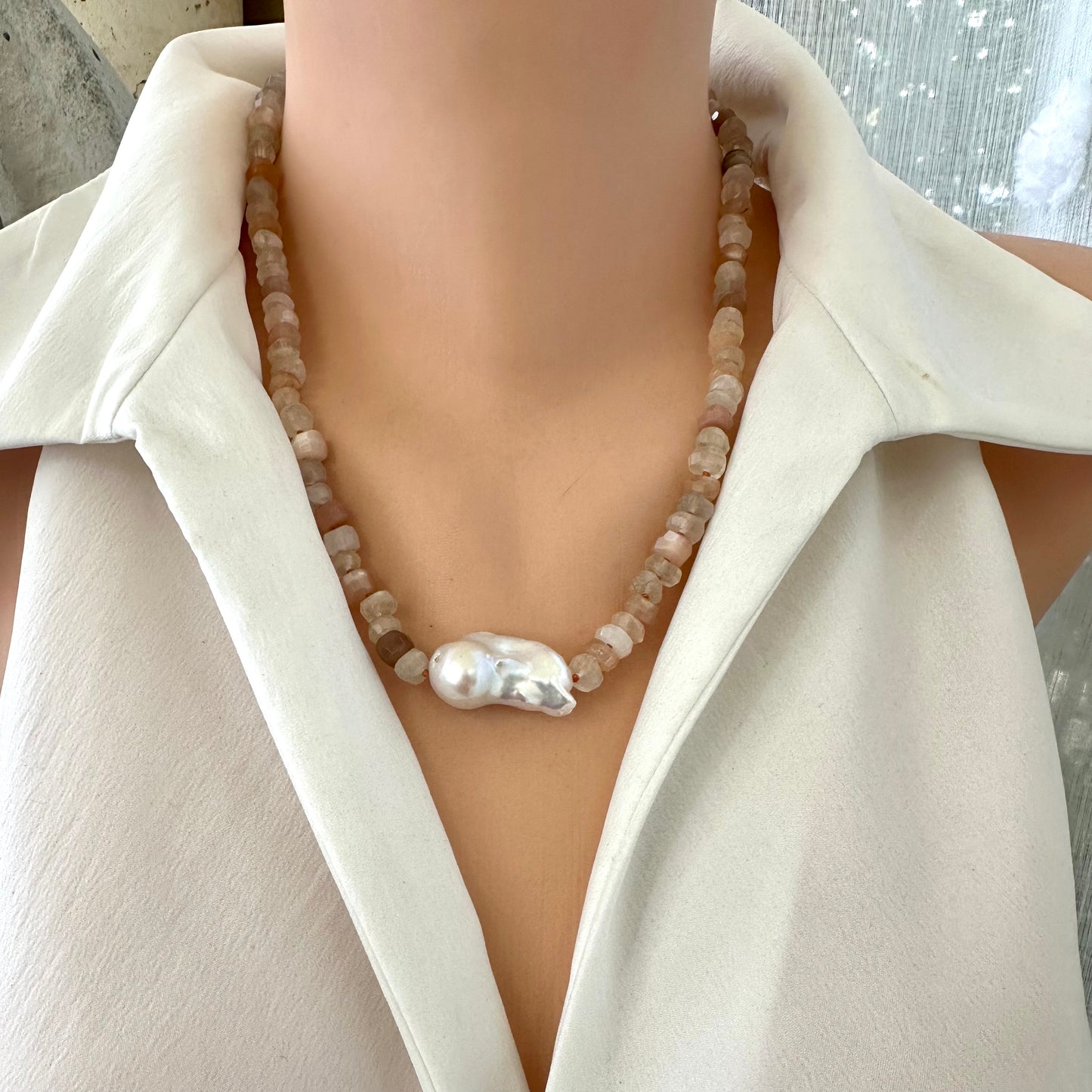 Close frontal view of mixed moonstone and baroque pearl necklace on mannequin