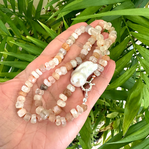 Hand-knotted necklace with mixed moonstone and a baroque pearl at the center, threaded with orange string, 20 inches long, featuring a sterling silver marine clasp.