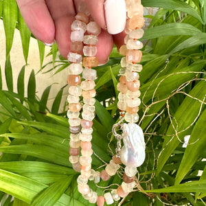 Hand-knotted necklace with mixed moonstone and a baroque pearl at the center, threaded with orange string, 20 inches long, featuring a sterling silver marine clasp.