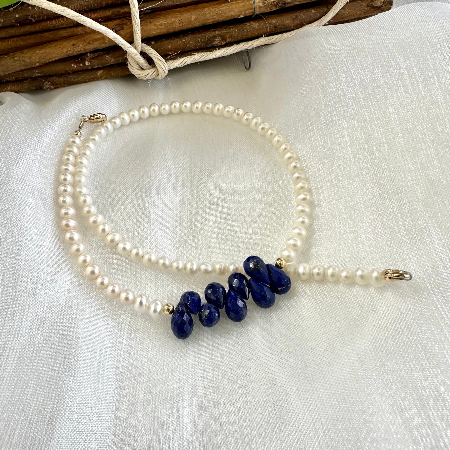 double wrap bracelet, featuring two strands of shimmering freshwater pearls beautifully accented with deep blue Lapis Lazuli teardrop briolettes, Gold filled details.