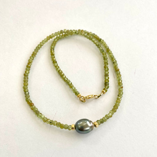 Peridot baroque pearl necklace featuring vibrant green Peridot beads and a Tahitian pearl centerpiece.