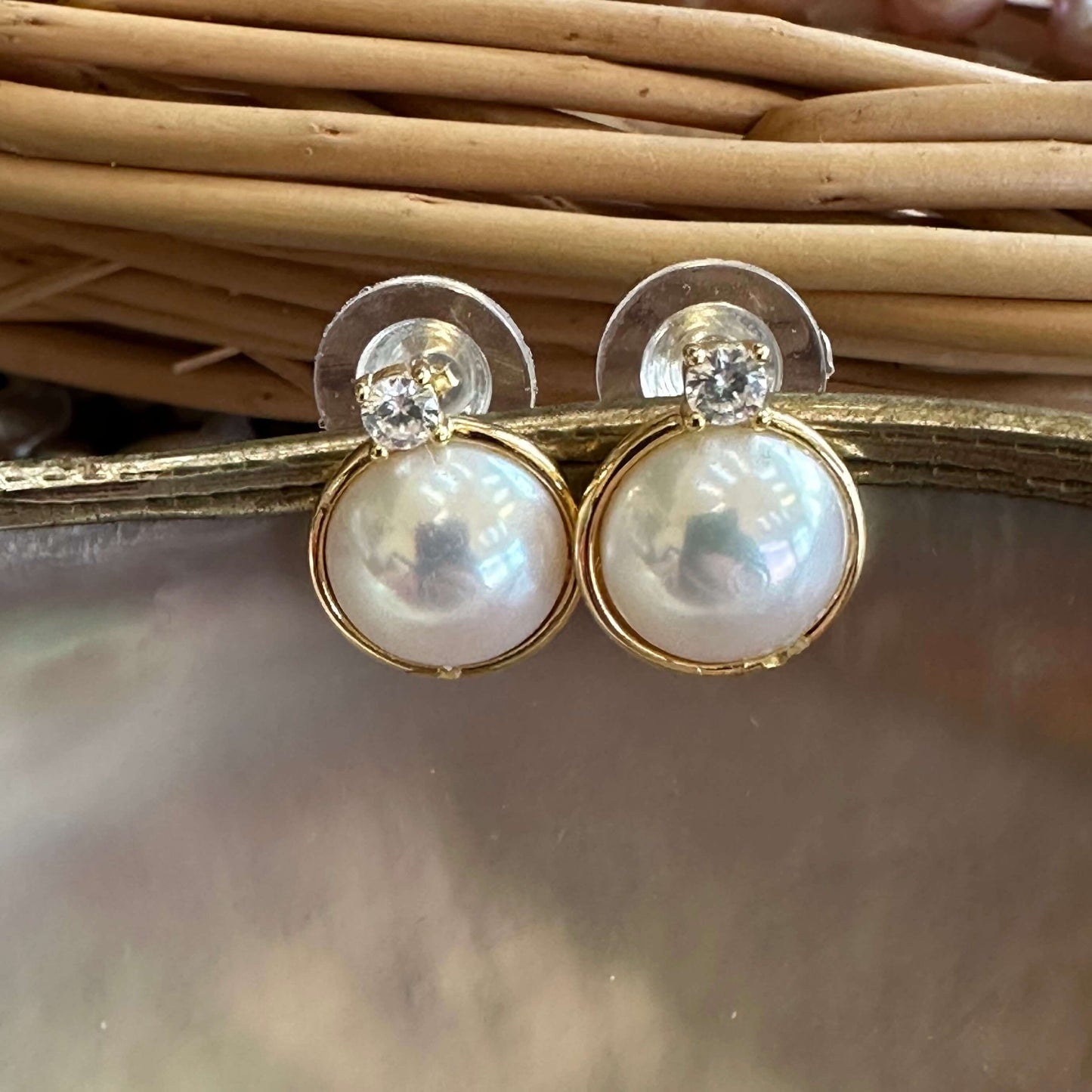 Mabe Edison pearl stud earrings in gold vermeil displayed on pearl and beige background