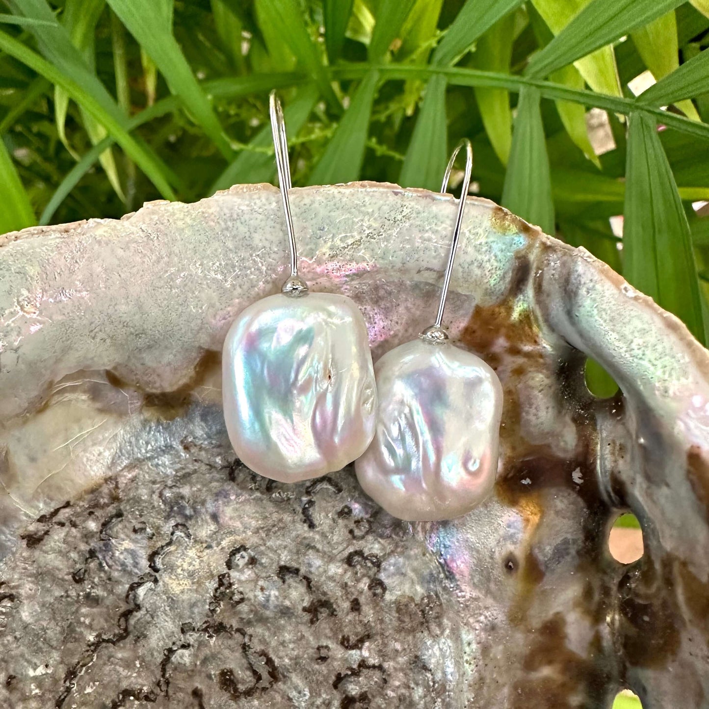 White freshwater pearl drop earrings gold vermeil detailed view against green leaves, elegant handmade jewelry from Canada.