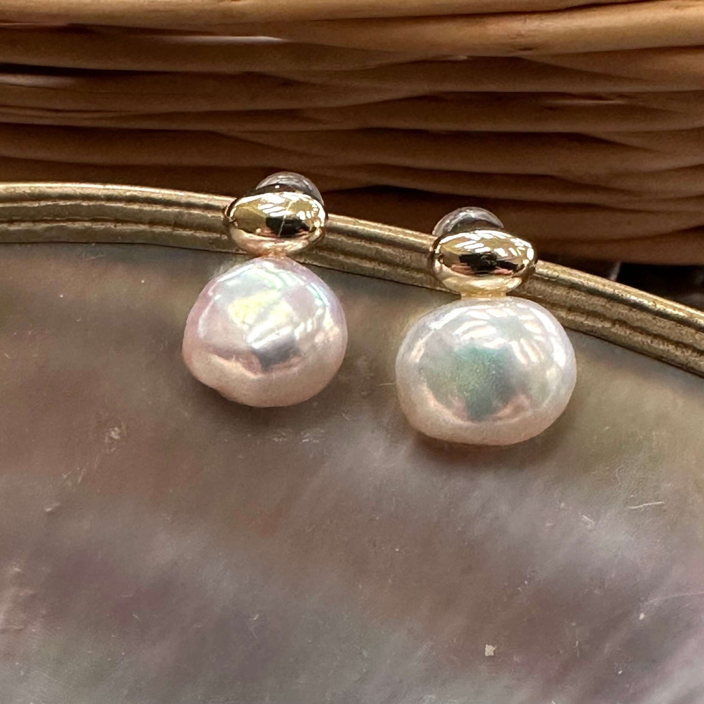 Handmade nugget pearl earrings with natural luster on shell background