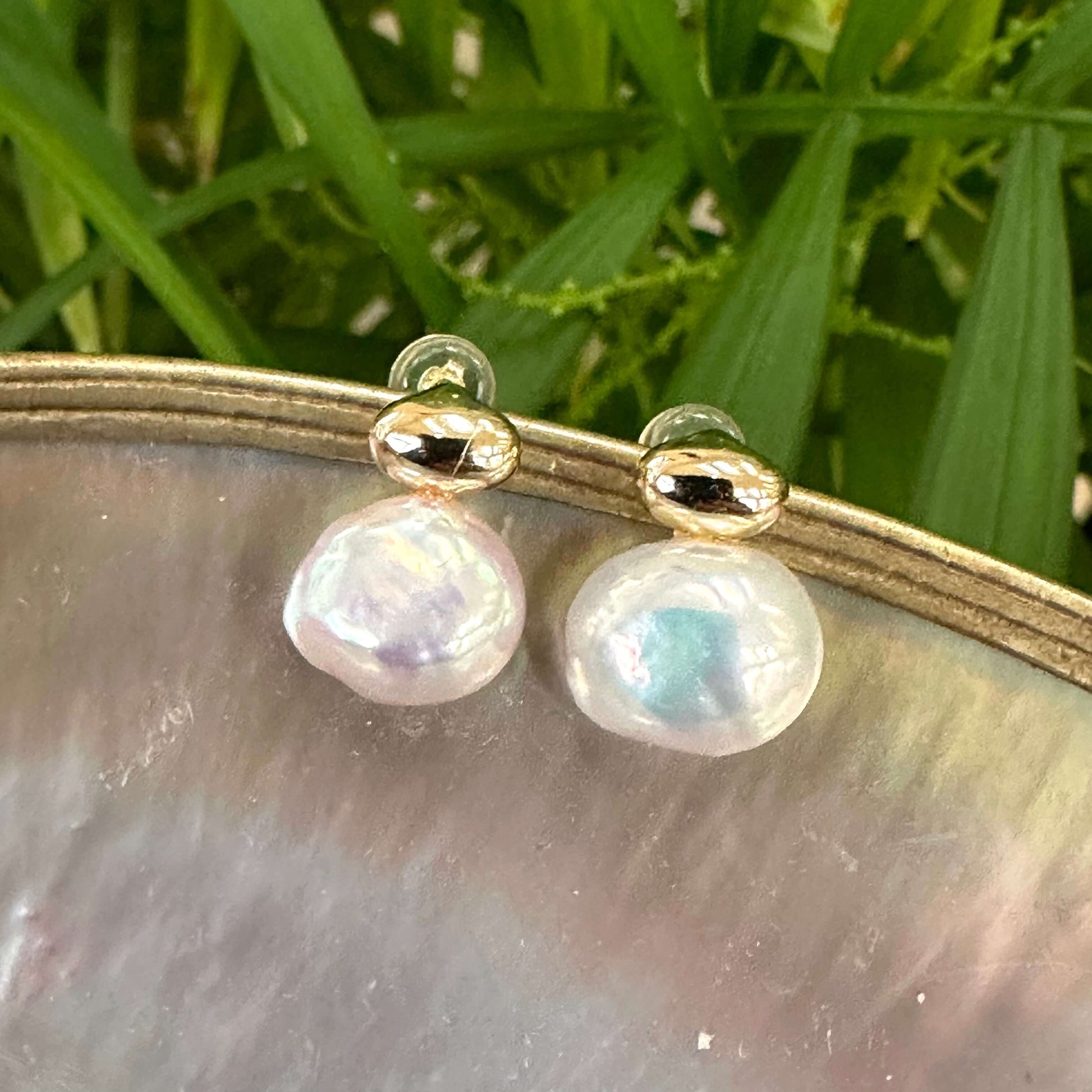 Nugget pearl stud earrings in gold vermeil on white pearl shell background