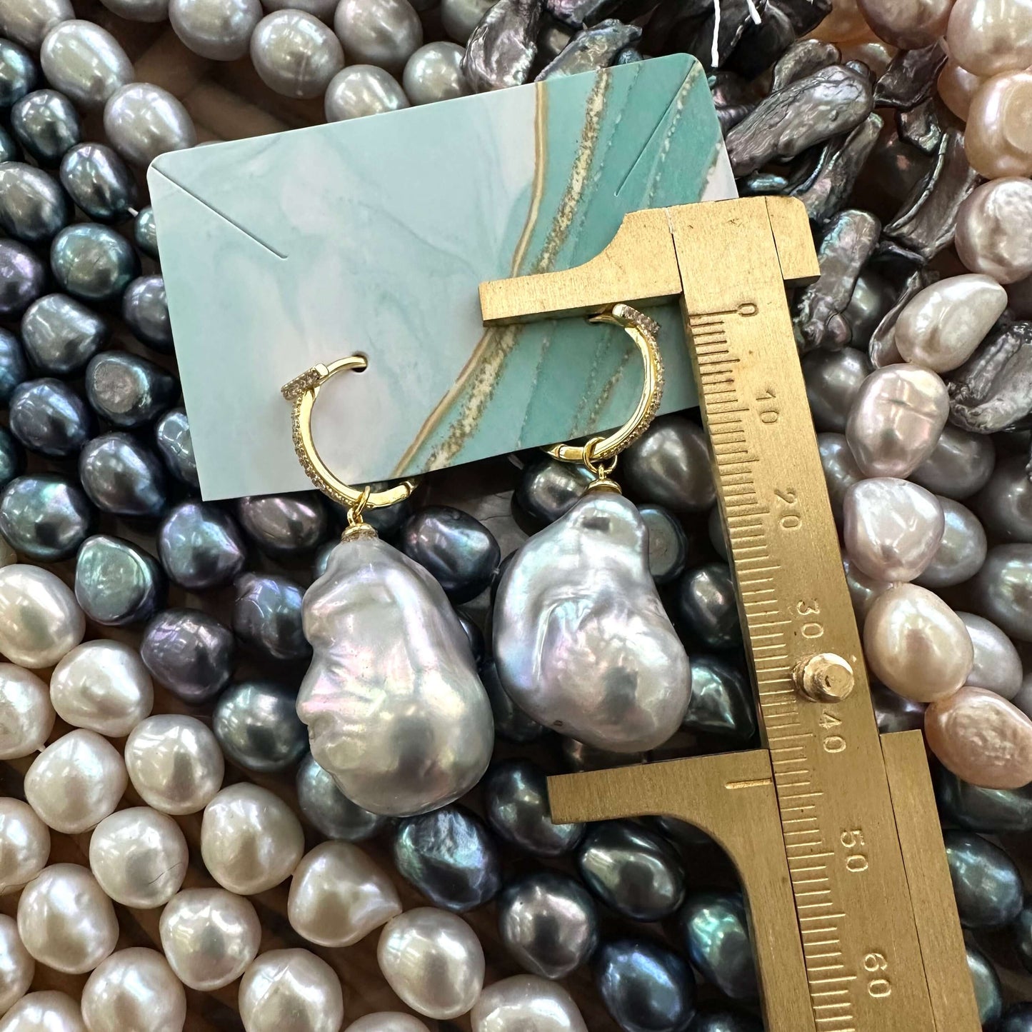 Grey baroque pearl hoop earrings measured for total drop length with ruler, designed and handmade in Canada.