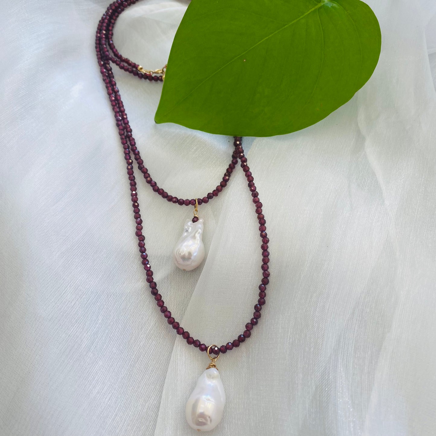 Red garnet baroque pearl necklace featuring red garnet beads and two exquisite Baroque pearl pendants.