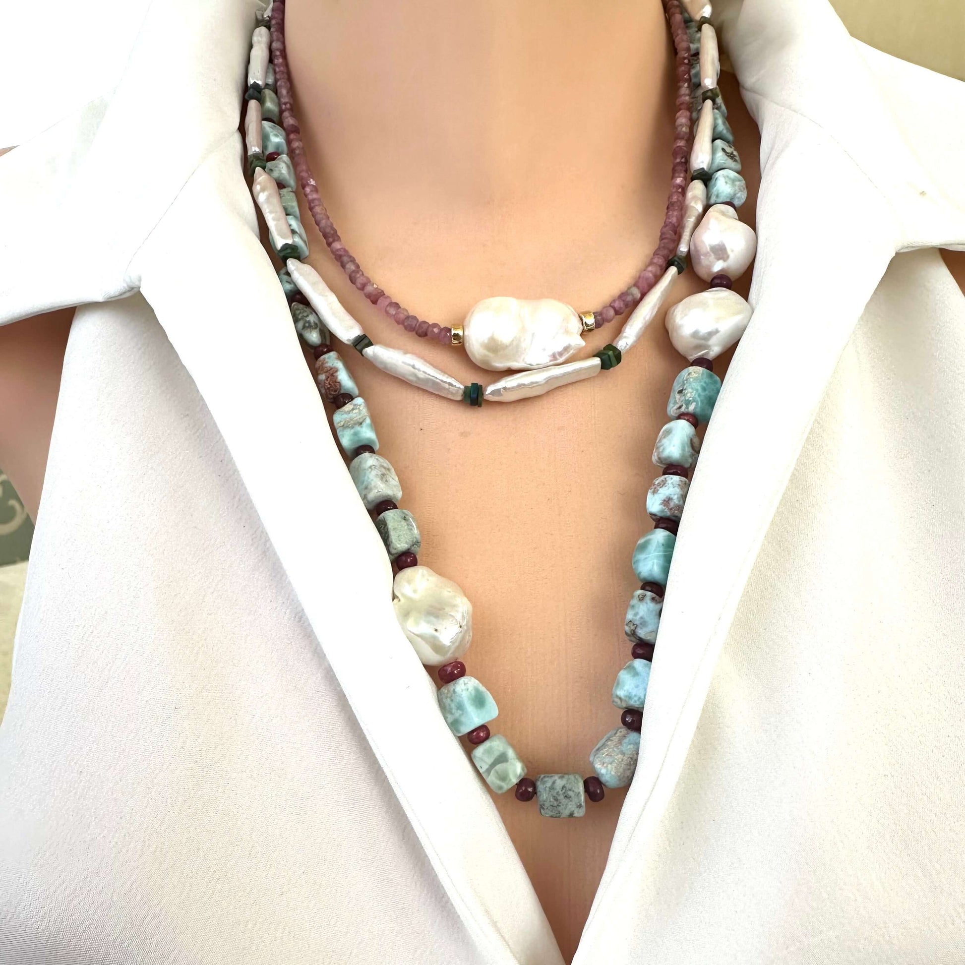 Larimar ruby and baroque pearl necklace layered with other pearl necklaces on mannequin, main product focus