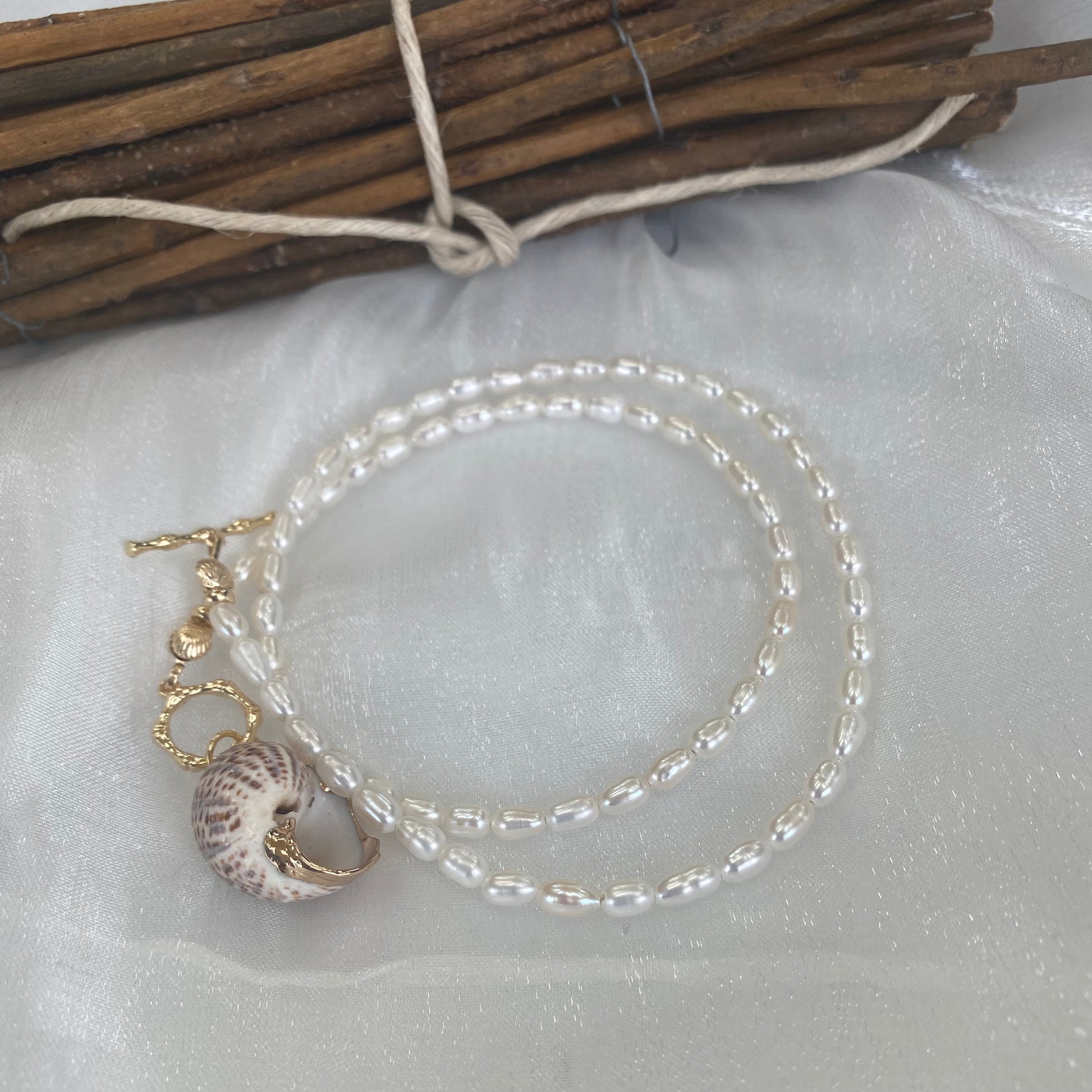 Real seashell pendant pearl necklace displayed flat highlighting seashell charm and pearl details