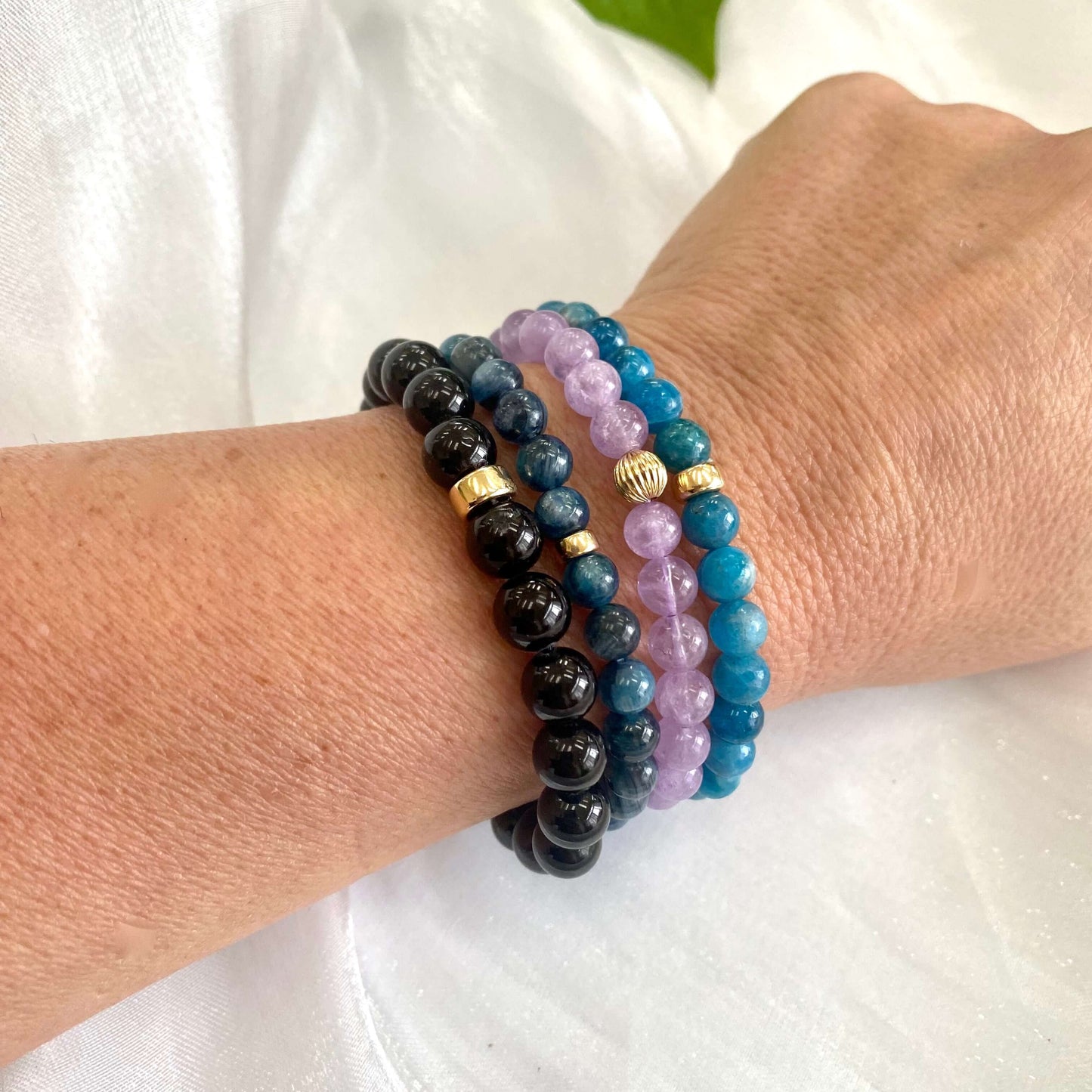 Blue Apatite Bracelet worn on woman’s wrist – layered with other bracelets