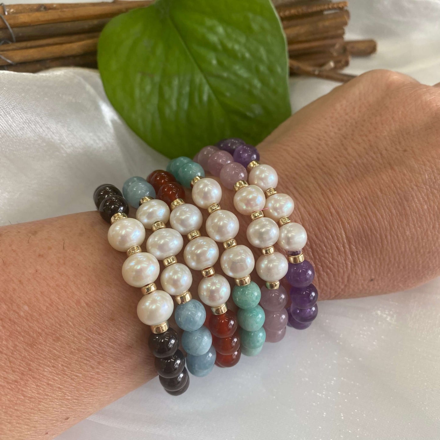 Amethyst Pearl Bracelet worn with other colourful bracelets on woman’s wrist – stacked look