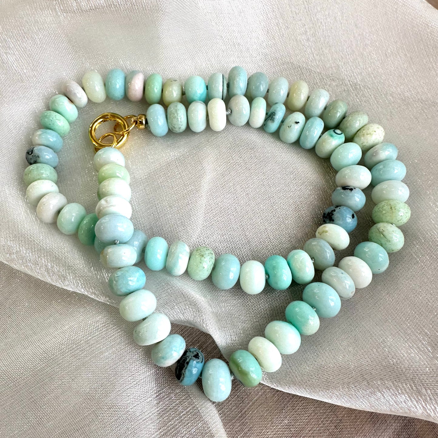 Blue Peru Opal Necklace Gold flat lay, coiled hand-knotted opal rondelle beads with vermeil push-lock clasp