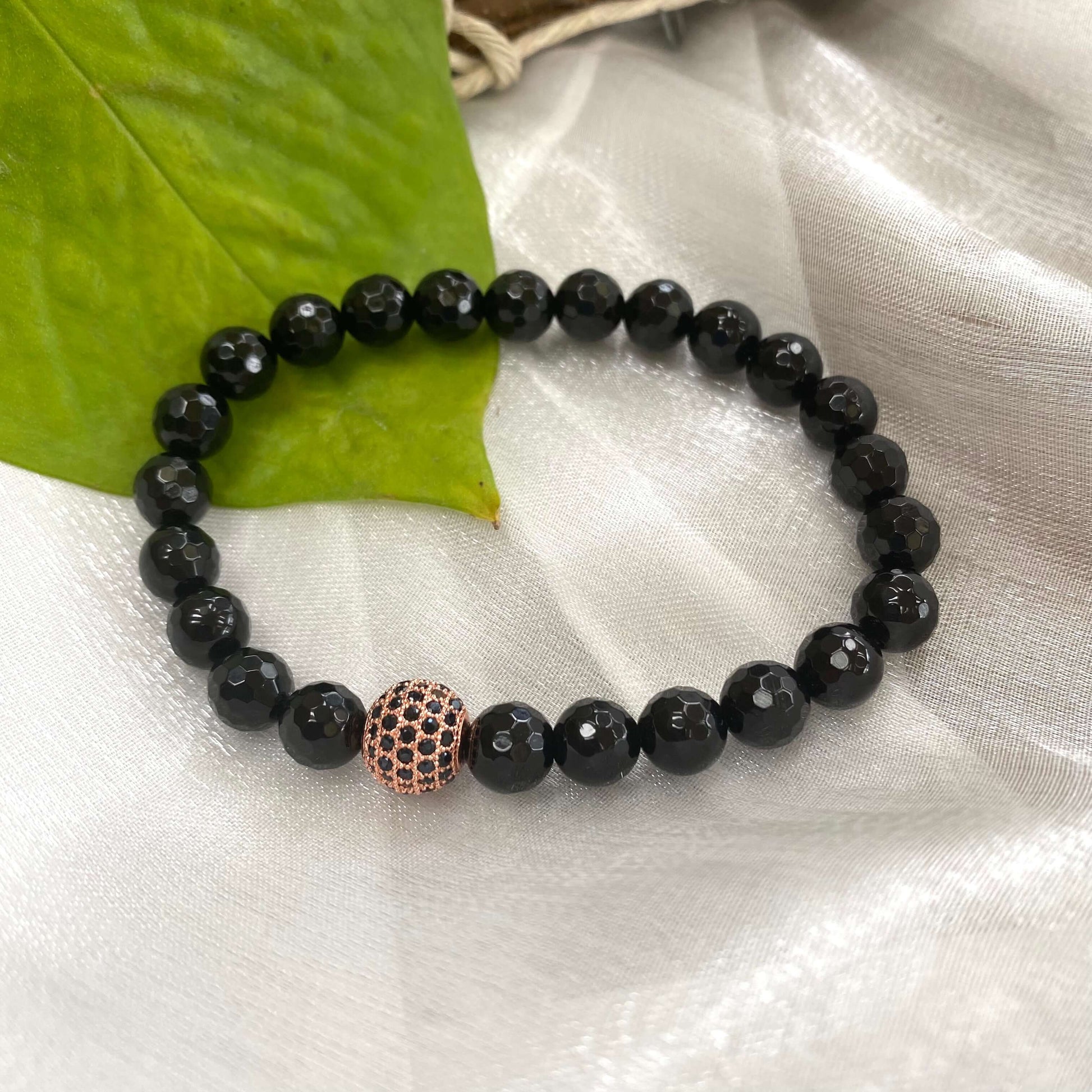 Black Onyx Mens Bracelet featuring stretch design and rose gold accents, handcrafted with 8mm faceted beads.