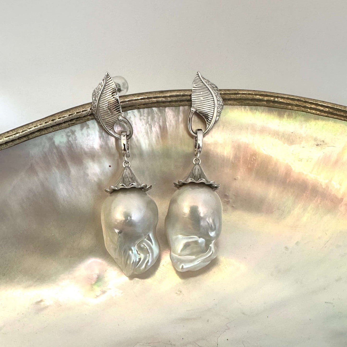 Detailed view of Leaf Design Baroque Pearl Earrings on white surface — polished sterling silver leaves and removable baroque pearls by Loulia Pearl Jewelry