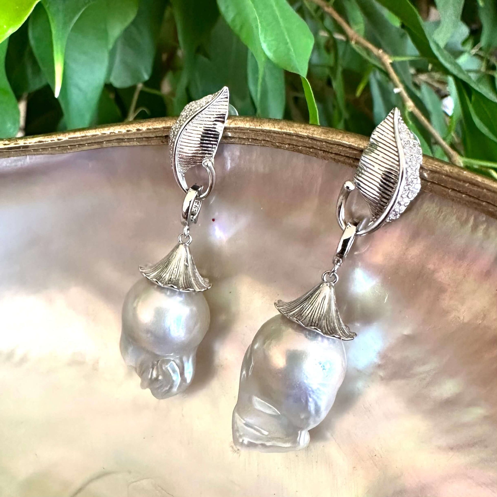 Leaf Design Baroque Pearl Earrings photographed against green leaf background — botanical sterling silver jewelry by Loulia Pearl Jewelry