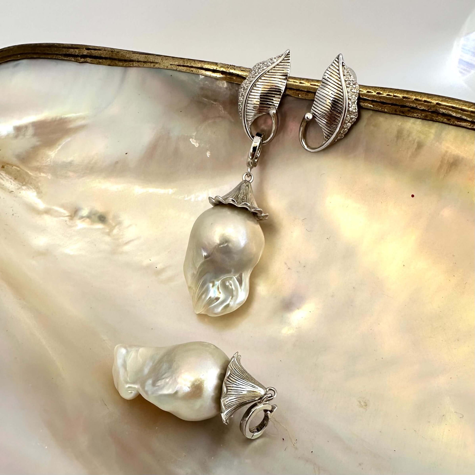 Close-up of Leaf Design Baroque Pearl Earrings on white pearl backdrop — sterling silver and genuine baroque pearls handcrafted by Loulia Pearl Jewelry