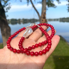 Load image into Gallery viewer, red coral and one large baroque pearl on the side of the necklace with sterling silver details, measuring 18 inches. This vibrant jewelry piece makes a thoughtful gift for her.
