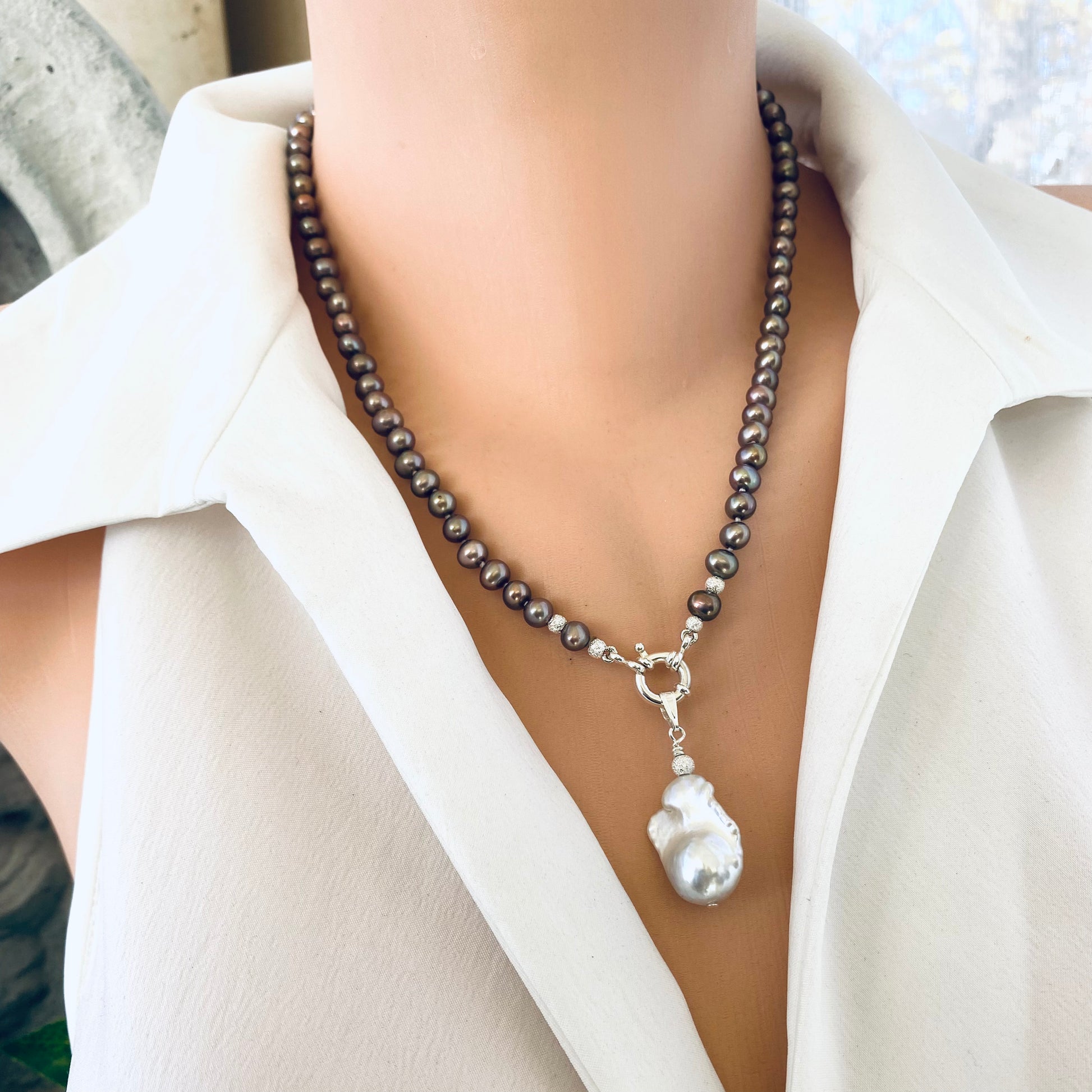 Handmade bronze pearl necklace with removable white baroque pendant displayed on mannequin, showing luminous luster and shape.