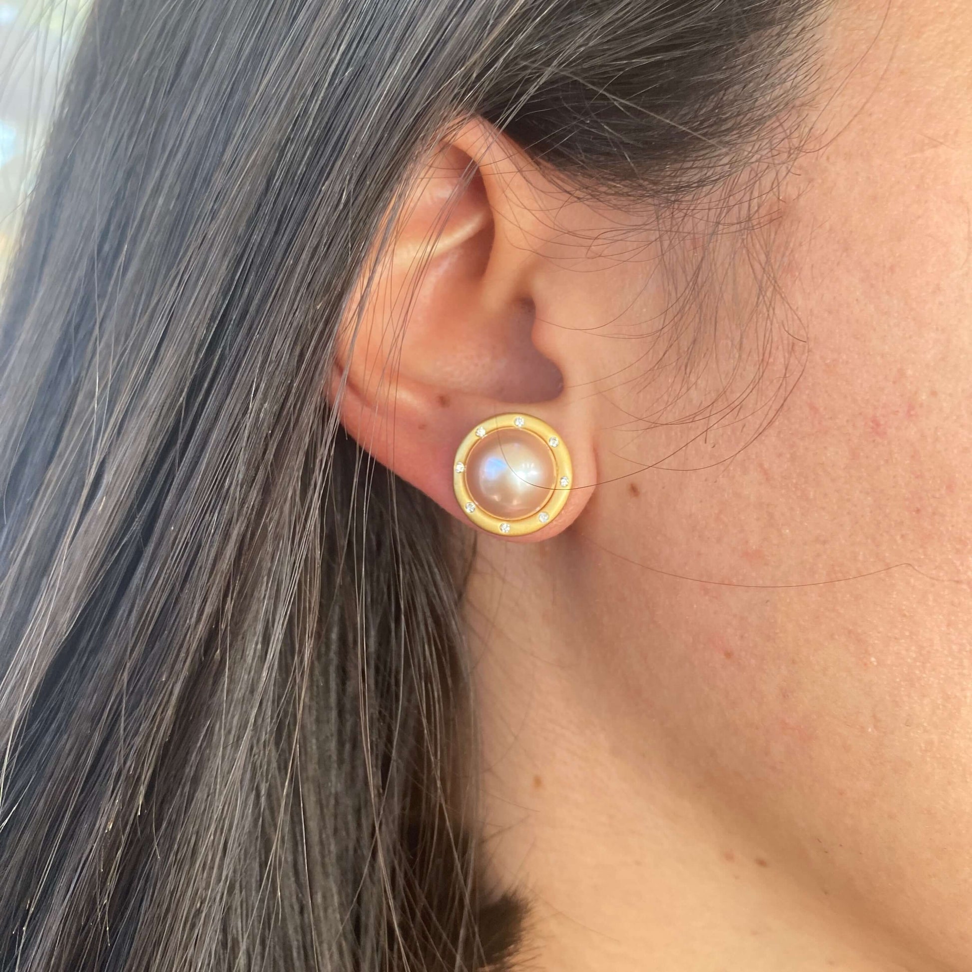 Model wearing pink mabe pearl stud earrings with CZ in gold vermeil, side view showing soft blush hue and elegant fit.