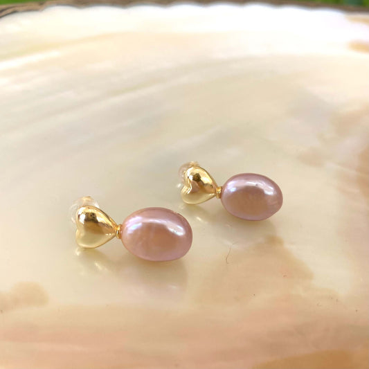 Heart Pearl Earrings – gold version close-up against white pearl shell