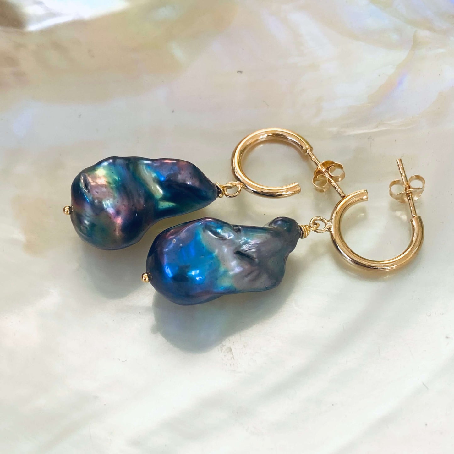 Black baroque pearl hoop earrings with gold vermeil finish on white pearl background