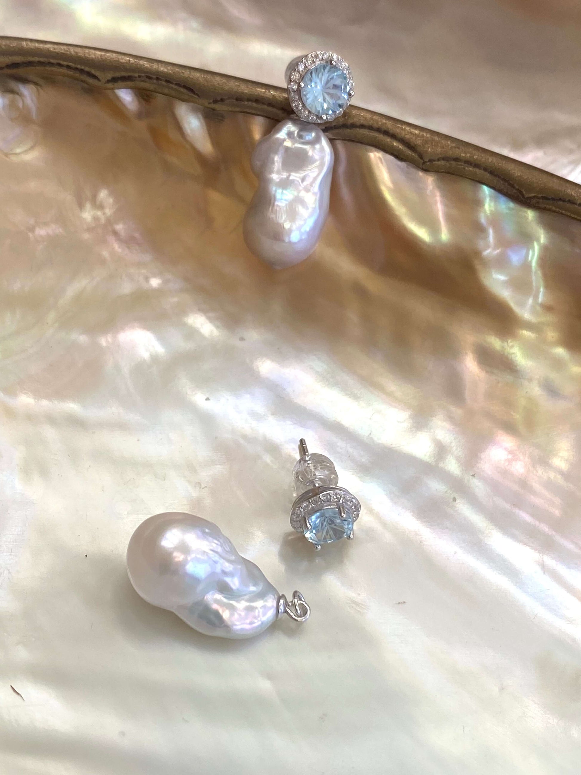 Convertible blue topaz pearl drop earrings with removable studs on shell background