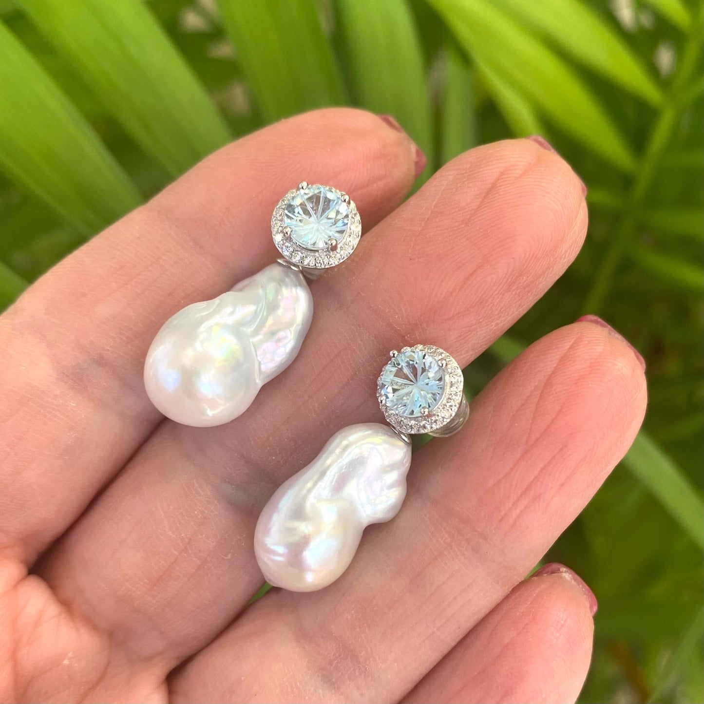 Blue topaz pearl drop earrings shown in hand for size reference, handmade in Canada
