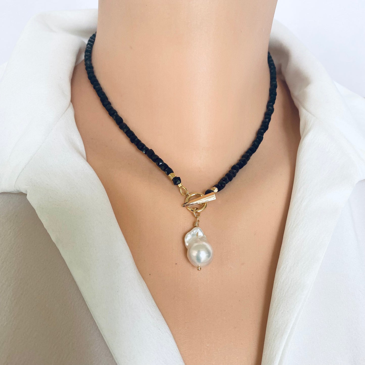 Black Tourmaline Choker Necklace with Pearl Charm displayed on a mannequin against a white background.